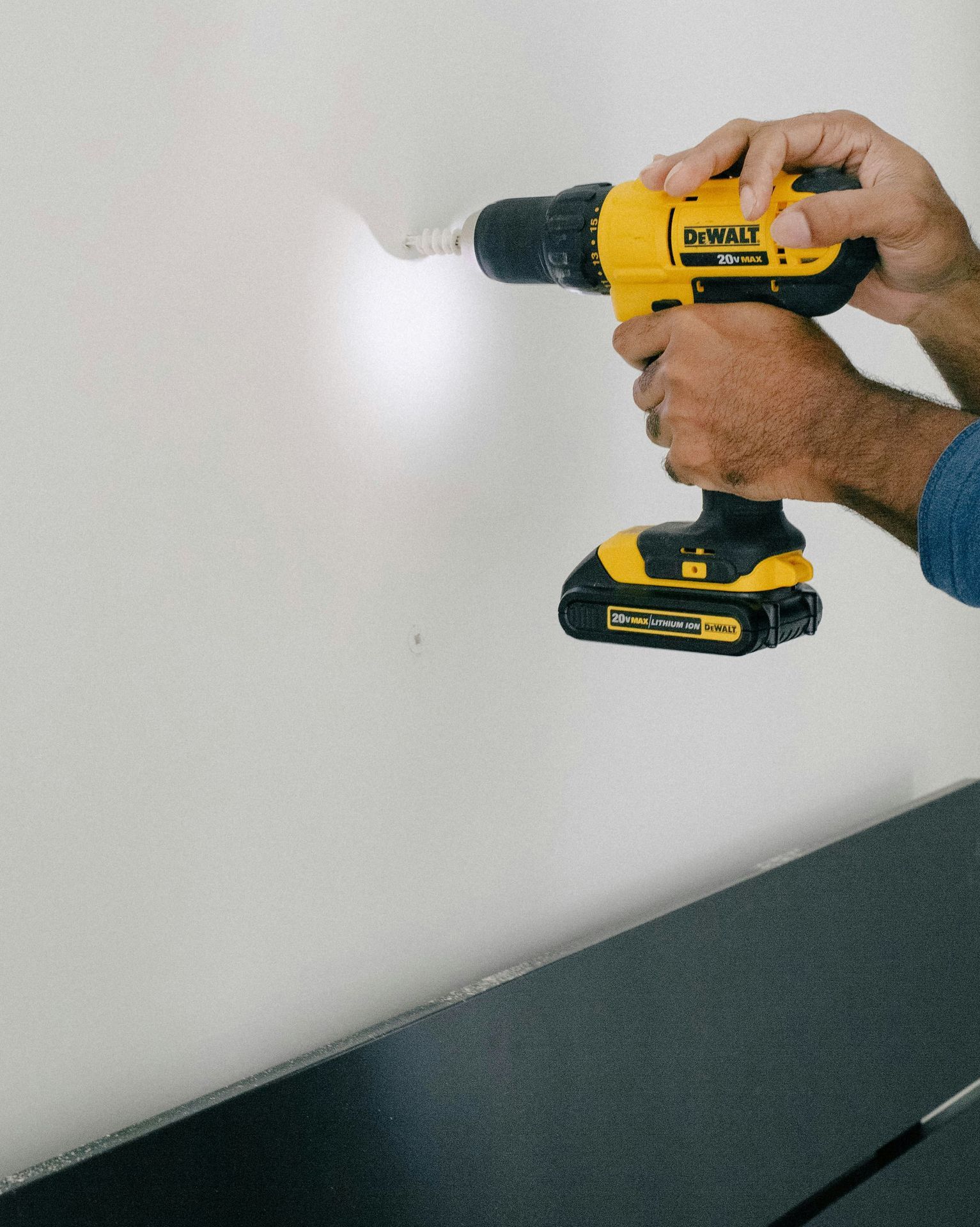 person holding yellow and black cordless hand drill